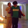 Josh helps a member of the audience try on the jacket